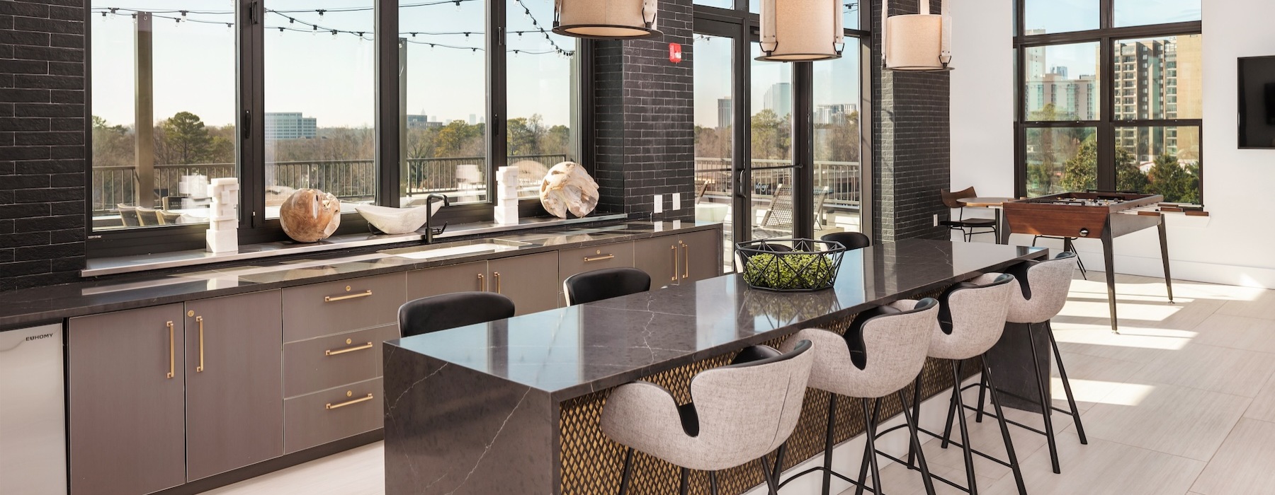 a spacious room with lounge seating a large windows at Alta Porter on Peachtree